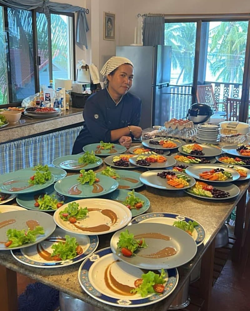 Private chef preparing a variety of gourmet dishes for a group in a luxurious villa.
